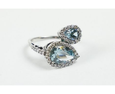 A contemporary 925 sterling silver ladies dress ring set with two large light blue stones of teardrop form and surrounded by 