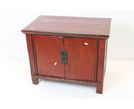 Chinese Red Lacquered Low Cabinet, the two doors opening to a shelf, 58cm high x 68cm long x 41cm deep 