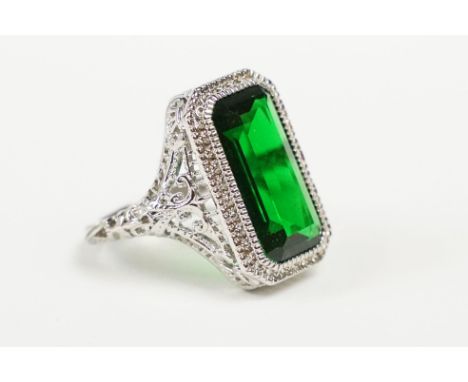 A 925 sterling silver ladies dress ring of classical style with green centre stone raised to pieced decorative platform, mark