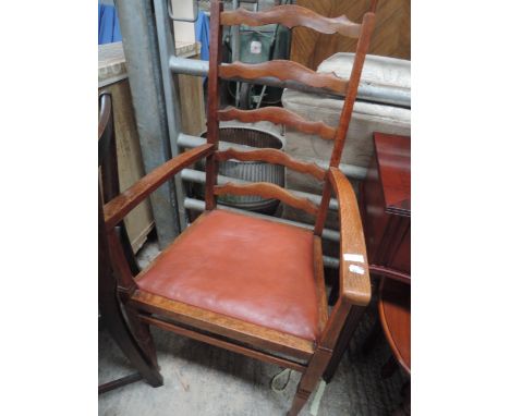 An early 20th century oak frame ladder back carver chair