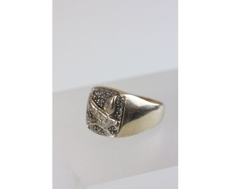 A 9 carat gold gentleman's signet ring, the head with a bird of prey in flight, enclosed by pave set single cut diamonds, fin