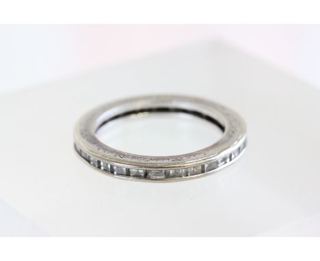 A diamond full eternity ring, the thirty baguette cuts set to an engraved edge white mount, finger size J1/2, cased