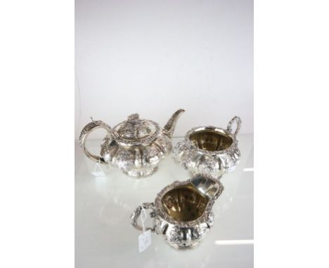 A William IV silver three piece tea service, by William Hewitt, London 1834 of compressed segmented form, embossed with folia