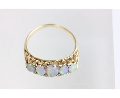 A five stone opal 18 carat gold ring, the graduated shallow cabochons with single cut diamond points in between, the carved h