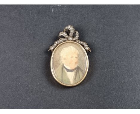 A Victorian yellow metal mourning pendant,&nbsp;having ribbon shaped diamond and black enamel surmount, with portrait miniatu