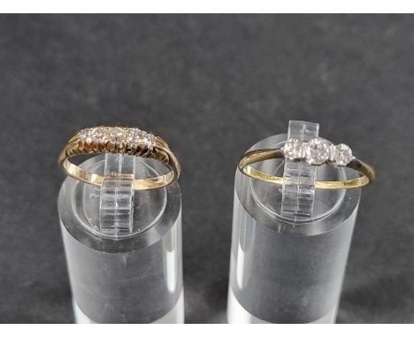 A yellow metal diamond three stone ring,&nbsp;size O; together with a diamond five stone ring stamped 18ct, size L 1/2. (2) 