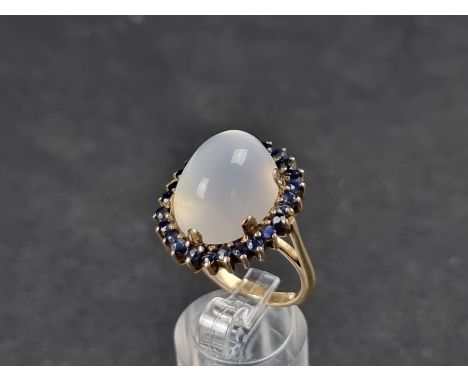 A yellow metal moonstone and sapphire cluster ring, size O. 