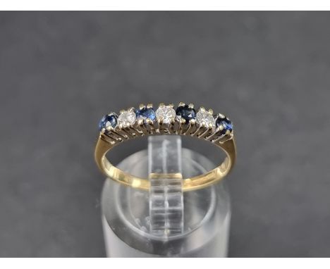 An 18ct gold half eternity ring, set four sapphires and three brilliant cut diamonds, Birmingham 1989, size N 1/2, gross weig