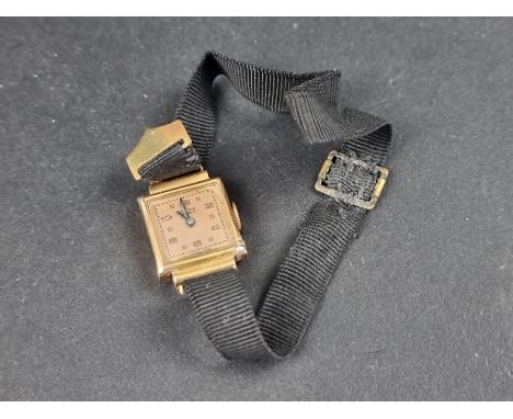 A vintage Swiss yellow metal manual wind ladies wristwatch, stamped 18k, 21 x 16mm, on a black fabric strap with plated clasp