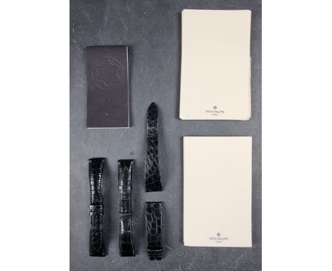 A group of three Patek Philippe leather watch straps, together with Patek Philippe headed paper and a Mont Blanc notepad. 