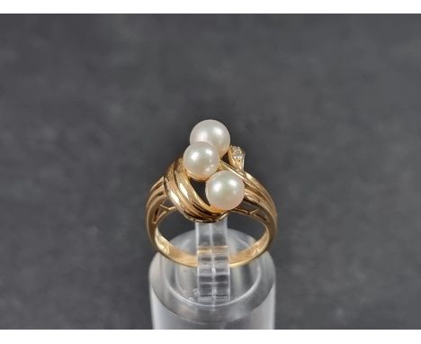 A yellow metal ring, set three pearls and three small diamonds, stamped 14k, size L. 