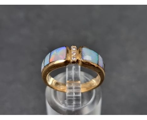 A modern yellow metal ring, set three graduated opal panels with three small brilliant cut diamonds to centre, stamped 14ct, 