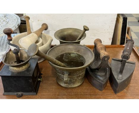 A Victorian coffee grinder, four pestle and mortars and two flat irons 
