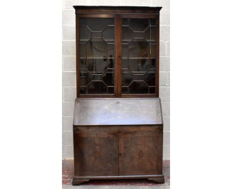 A George III mahogany bureau bookcase, with dentil cornice above two astragal glazed doors enclosing shelves, over a fall fro