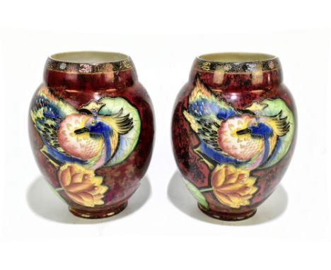 CARLTON WARE; a pair of ovoid form vases, decorated with exotic birds and stylised foral motifs on a mottled ruby ground, pri