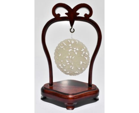 A Chinese carved jade circular plaque decorated and engraved to both sides with figures, an exotic bird and scrolls, diameter