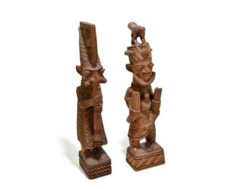 JOSEPH ADEYEMI FAKEYE (NIGERIAN, born 1931); a west African carved wood figure, modelled playing a musical instrument, signed