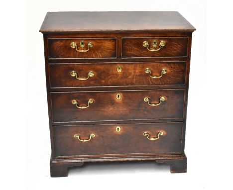 A George III oak chest, the rectangular top with a moulded edge above two short and three graduated long drawers, on bracket 