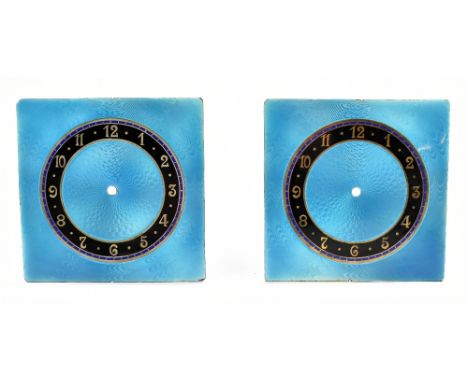 Two Arts &amp; Crafts enamelled white metal clock dials with black and blue Arabic numeral chapter rings and pale blue guillo
