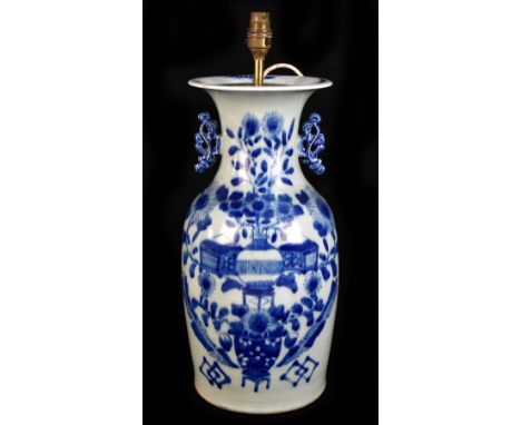 A late 19th century Chinese blue and white ceramic twin handled vase, decorated with objects and floral sprays on a celadon g