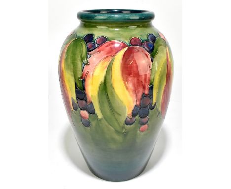 WILLIAM MOORCROFT; a large vase with rolled neck decorated in 'Leaf and Berry' pattern on a green ground, impressed marks and