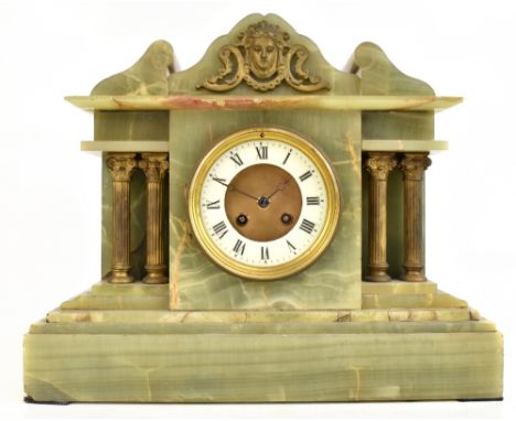 A Victorian onyx mantel clock of architectural from with applied gilt metal mask head decoration to the top, the circular dia