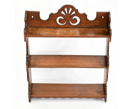 An Edwardian oak hanging shelf, with three open shelves and serpentine sides, height 23cm, width 54cm, together with an oval 