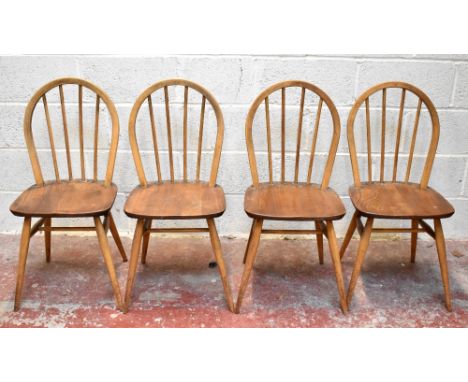 A set of four beech and ash Ercol style Windsor country kitchen chairs, with hoop shaped backs and solid seats on turned legs