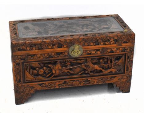 An early to mid 20th century Chinese camphor wood lined and carved and stained wood blanket box, the panelled top carved in d