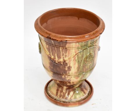 A modern terracotta garden planter with moulded detail and decorated with a mottled blue and green glaze, on circular stand, 