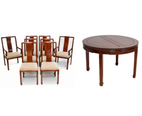 A Chinese hardwood circular extending dining table and eight chairs, the table with two spare leaves with a moulded frieze an