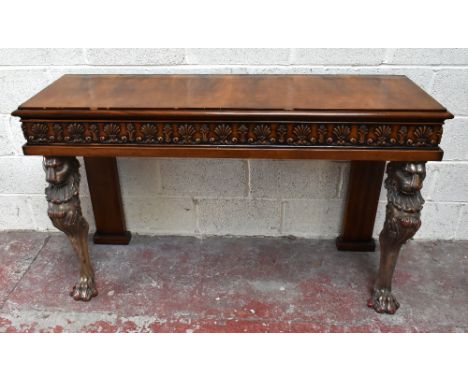 A Regency style walnut console table, with moulded rectangular top above a detailed freize, on two lion head monopodia legs, 