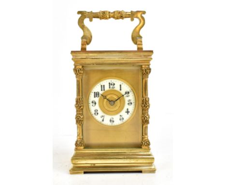 A 19th century French carriage clock, with cast decoration to the swing handle and corners, the circular enamelled dial set w