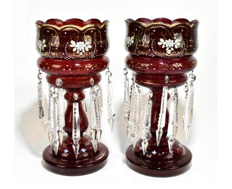 A pair of late Victorian ruby coloured glass table lustres, with enamelled floral decoration and clear glass droplets, height