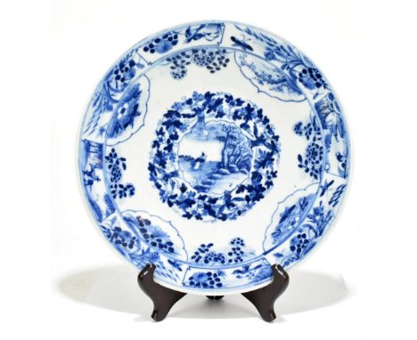 A late 19th century Kangxi style plate decorated in underglaze blue with floral panels, figures and birds, six character mark