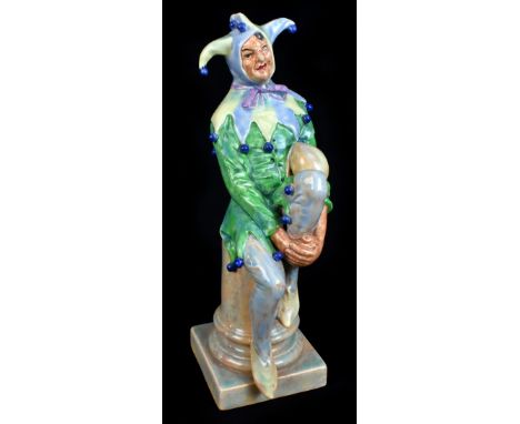 ROYAL DOULTON; a rare figure of a seated Jester originally designed by Charles Noke, impressed number 3940 to underside, heig