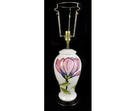 MOORCROFT; a table lamp decorated in 'Magnolia' pattern on an ivory ground, raised on turned wooden plinth base, height exclu