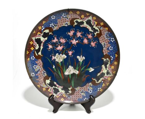 A Japanese cloisonné wall charger centrally decorated with iris inside a scrolling border with insects, with wire work border