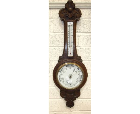 An aneroid barometer/thermometer with carved oak case, 87cm high.