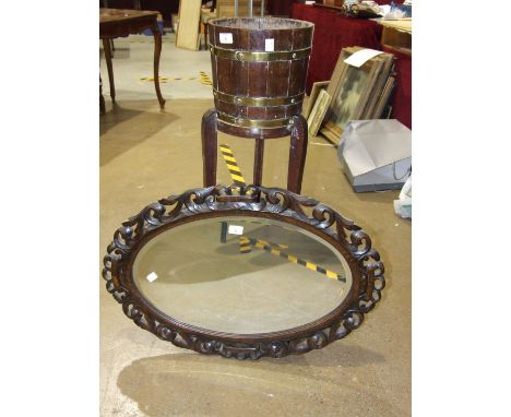 An oak brass-bound coopered planter on stand, 97cm high, 26cm diameter and a carved oak oval frame mirror, (2).