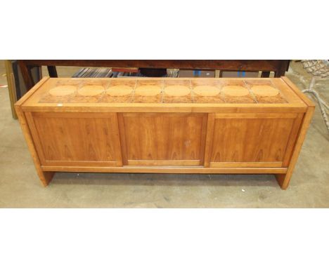A retro hardwood low sideboard, with ceramic tiled top above three sliding panel doors, 190cm long, 70cm high.
