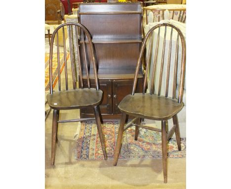 An Ercol-style set of open bookshelves fitted with a pair of base doors and a pair of stick-back dining chairs, (3).