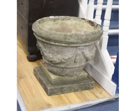 A circular reconstituted stone garden planter on square plinth, diameter 49cm, height 46cm