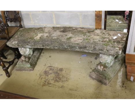 A pair of reconstituted stone garden benches of curved rectangular form with recumbent lion supports, length 180cm, depth 53c