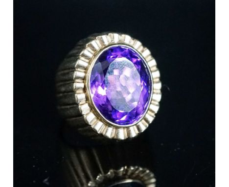 A yellow metal and oval cut amethyst set dress ring, with fluted setting, size Q/R, gross 17 grams.