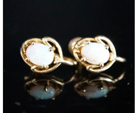 A modern pair of 585 yellow metal and oval white opal set ear clips, 12mm, gross weight 3.2 grams.