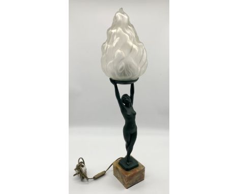 A green patinated Art Deco lamp in the form of a nude lady holding aloft a flame shaped glass shade on onyx base