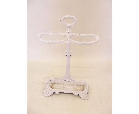 A Victorian white painted cast iron stick stand on scroll supports