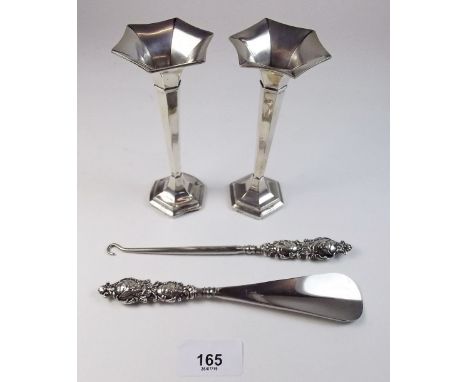 A pair of small silver vases, a silver handled shoe horn and a button hook
