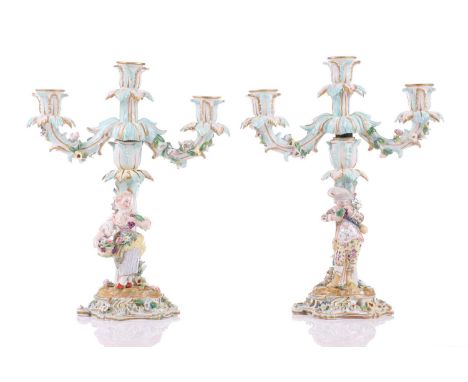 A pair of German porcelain figural three sconce candelabra, with tre stum stems mounted with a brightly dressed Dandy and his